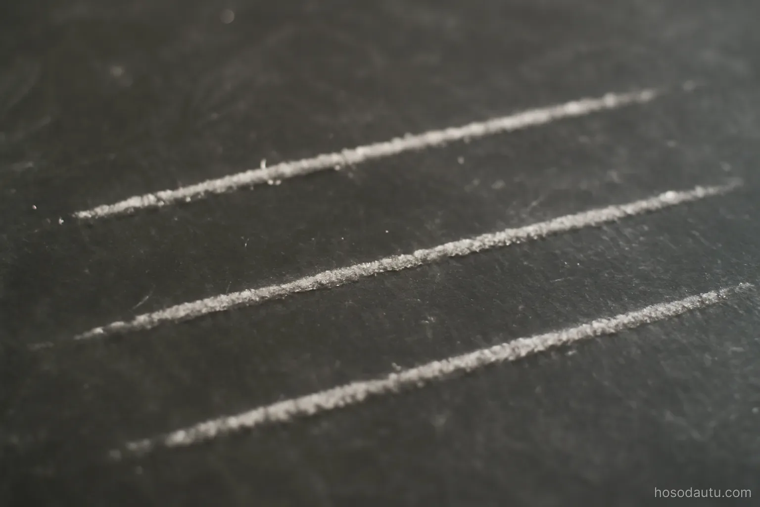 three parallel chalk lines drawn on a dark board with small marks along them, close view, no numbers or words