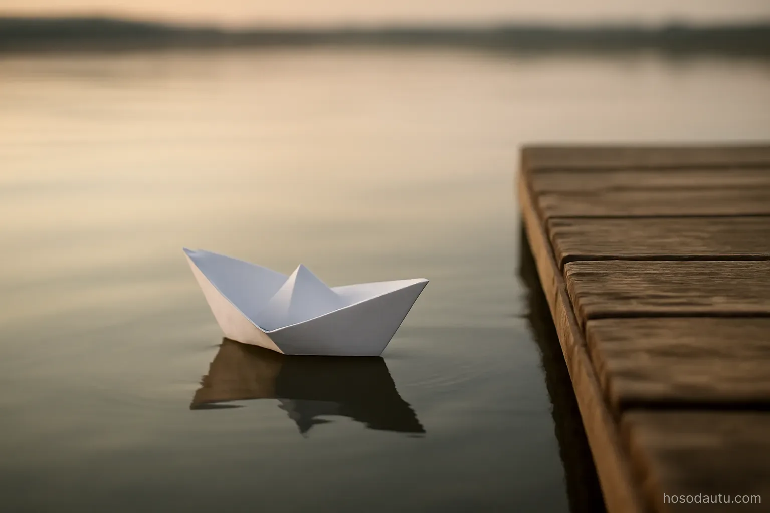 a paper boat floating on still water near a wooden dock, soft evening light, plain surroundings