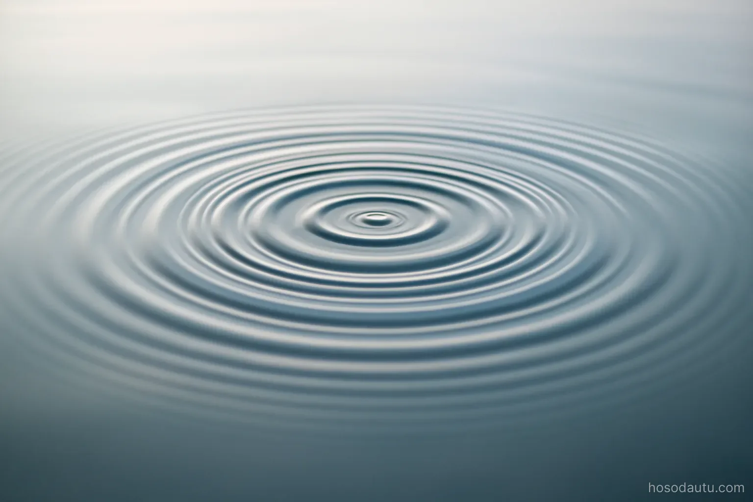concentric ripples spreading on the surface of still water, close overhead view, plain background